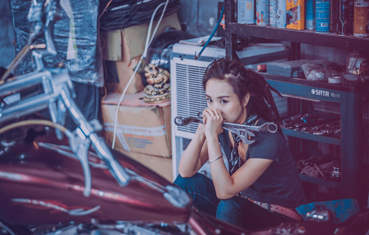 A woman with tools looking pensive