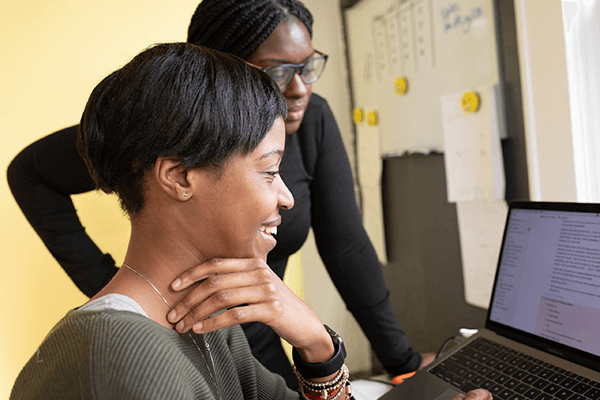 A woman with a mentor looking at a computer