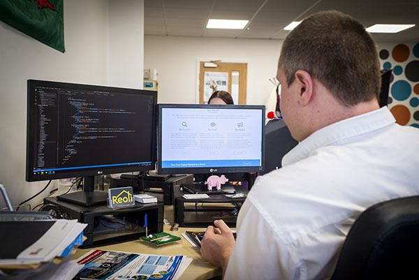 Man working on two screens